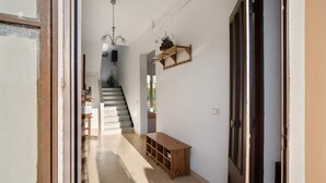 A hallway with a wooden bench, a staircase, and a wall-mounted shelf with a plant. - Holiday Home 'Ca' Del Sole' with Sea View, Private Garden and Wi-Fi (Civezza)