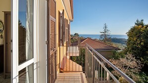 A balcony with a view of the sea and hills, a door, and a window with shutters. - Holiday Home 'Ca' Del Sole' with Sea View, Private Garden and Wi-Fi (Civezza)