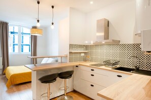 Una cocina moderna con estufa integrada, un lavaplatos y una barra con taburetes.