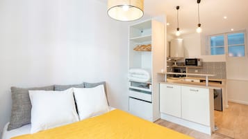 Tabla de planchar con plancha y ropa de cama