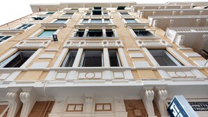 Un edificio con varias ventanas, una puerta y un letrero que indica que es un negocio.
