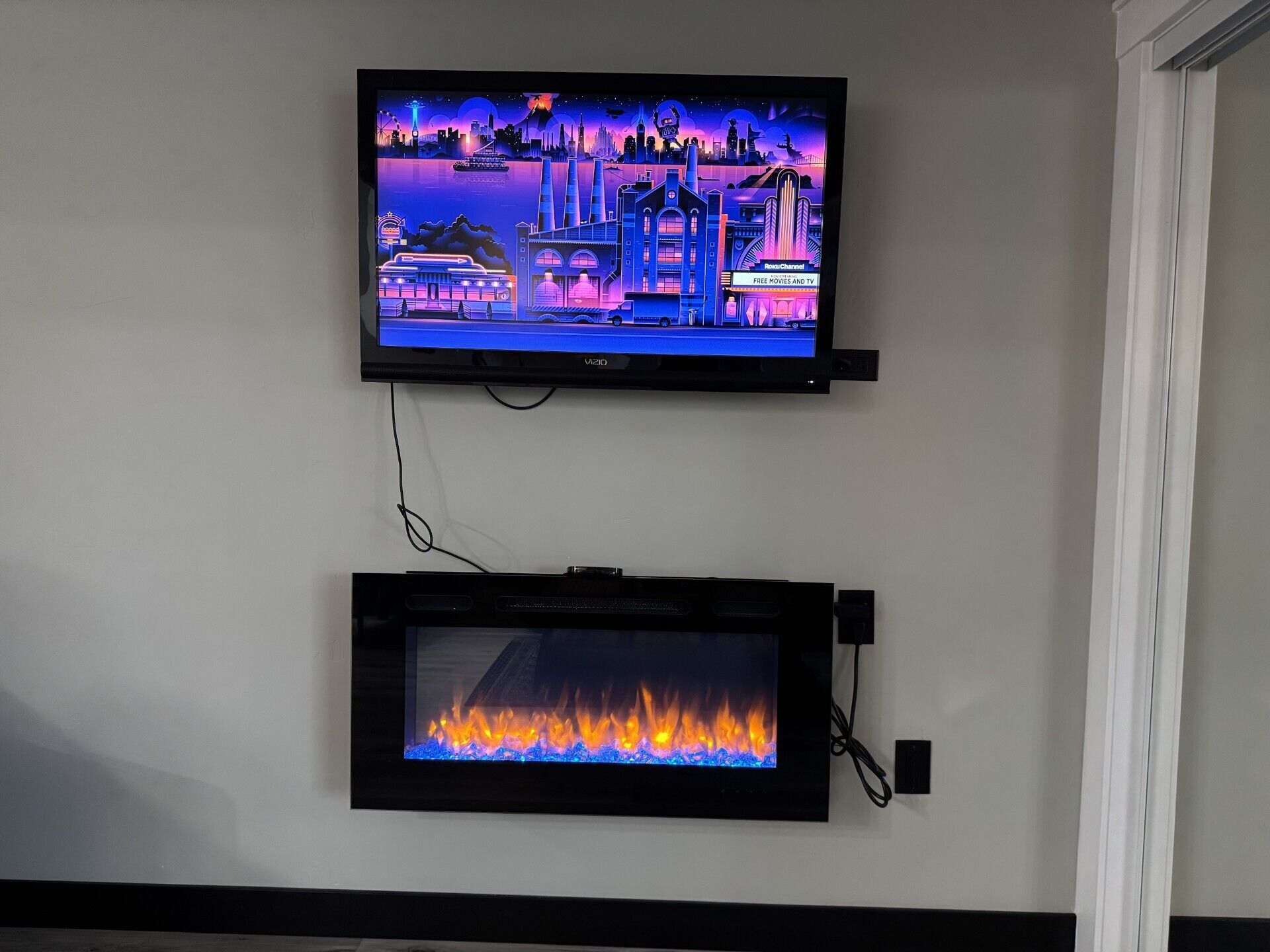 A flat-screen TV mounted on a wall above a fireplace.