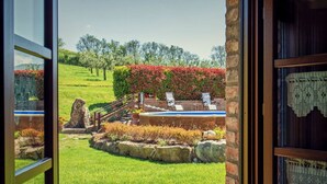 A pool area with lounge chairs, a stone structure, and a hedge. - Villa Podere del Papa by MMega (Pienza)