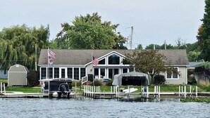 Une maison avec un quai, un drapeau américain et un garage.