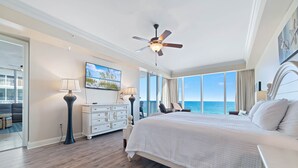 A spacious bedroom with a large bed, a ceiling fan, and a view of the ocean. - Mediterranean West 601W | Next to Florabama | Heated Indoor Pool w/Swim-Thru | My Beach Getaways (Pensacola)