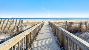 A wooden boardwalk leading to a beach with a clear sky. - Mediterranean West 601W | Next to Florabama | Heated Indoor Pool w/Swim-Thru | My Beach Getaways (Pensacola)