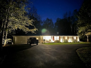 A two-story building with a garage, a driveway, and a lawn.