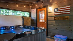 Ein Whirlpool mit Holzwand, einem Warnschild und einer Tür mit Pfotenabdruck-Dekoration.
