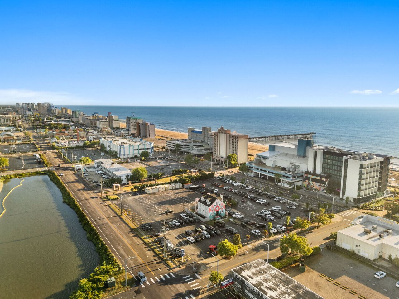 Vista aérea de uma cidade costeira com um porto de iates, estacionamentos e diversos edifícios.