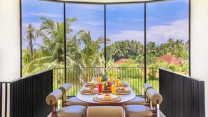 Comedor con un amplio ventanal que da a un paisaje tropical.