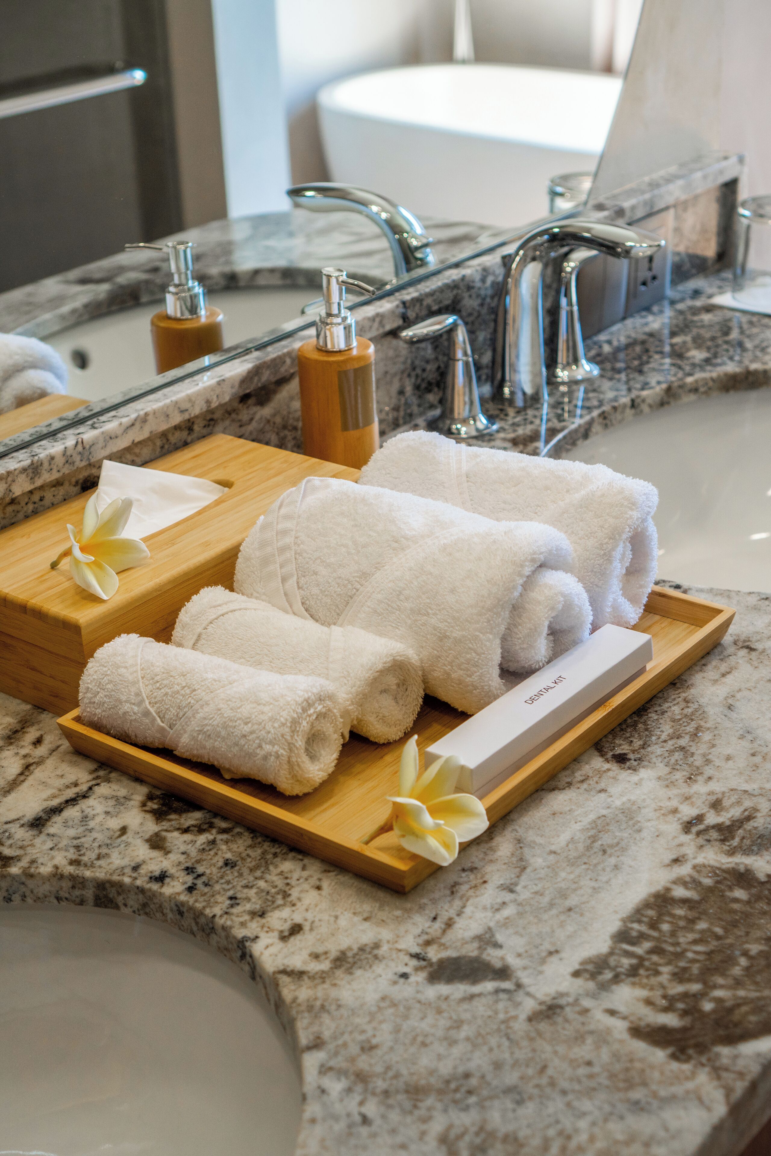 A bathroom with a marble countertop, a sink, and two faucets. There are towels and a box labeled "DEPOSIT" on the counter.