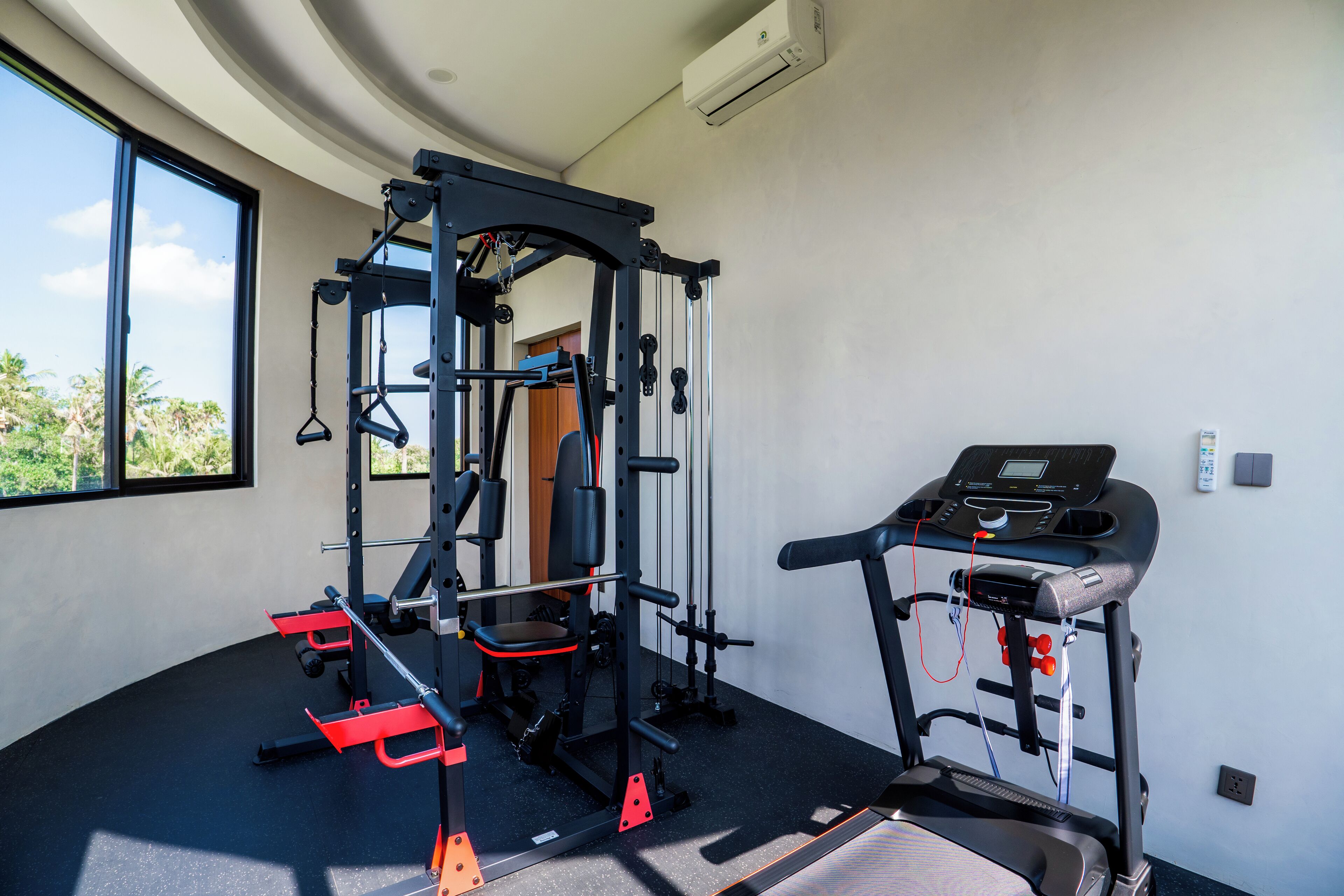 A gym with a pull-up bar, weight bench, and a treadmill.