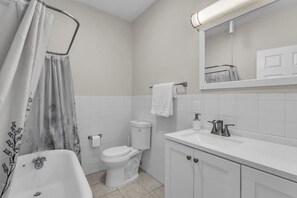 Et badeværelse med badekar, toilet og vask.