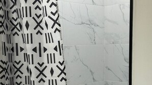 A bathroom with a shower curtain featuring a geometric pattern. - Neverland. (Jacksonville)
