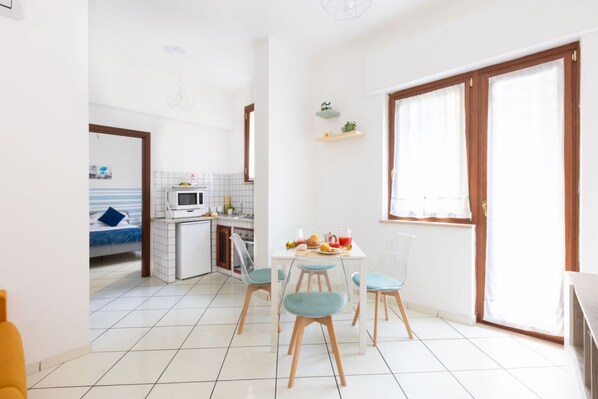 Un espacio habitable pequeño con cocina, comedor y un dormitorio.