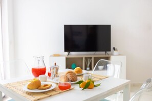A breakfast table with pastries, a pitcher of red drink, and a glass of water. - Charming&Modern One-Bedroom Apartment in Sorrento (Sorrento)