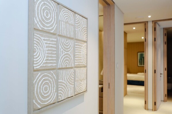 Un pasillo con una obra de arte moderna en la pared, con motivos geométricos.