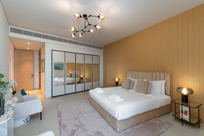 Une chambre à coucher moderne avec un grand lit, des lampes de chevet, une armoire et un luminaire au plafond.