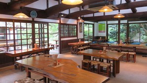 A traditional Japanese inn with wooden furniture, large windows, and hanging paper lamps. - Nokonoshima Island Park Villa Sakimori (Fukuoka)