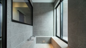 A modern bathroom with a built-in bathtub, large windows, and a mirror. - Nokonoshima Island Park Villa Sakimori (Fukuoka)