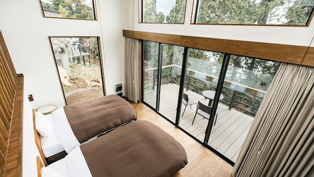 A bedroom with a large window overlooking a deck. - Nokonoshima Island Park Villa Sakimori (Fukuoka)