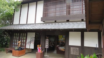 Un edificio tradicional japonés con fachada de madera, techo de tejas y una pequeña entrada a una tienda.