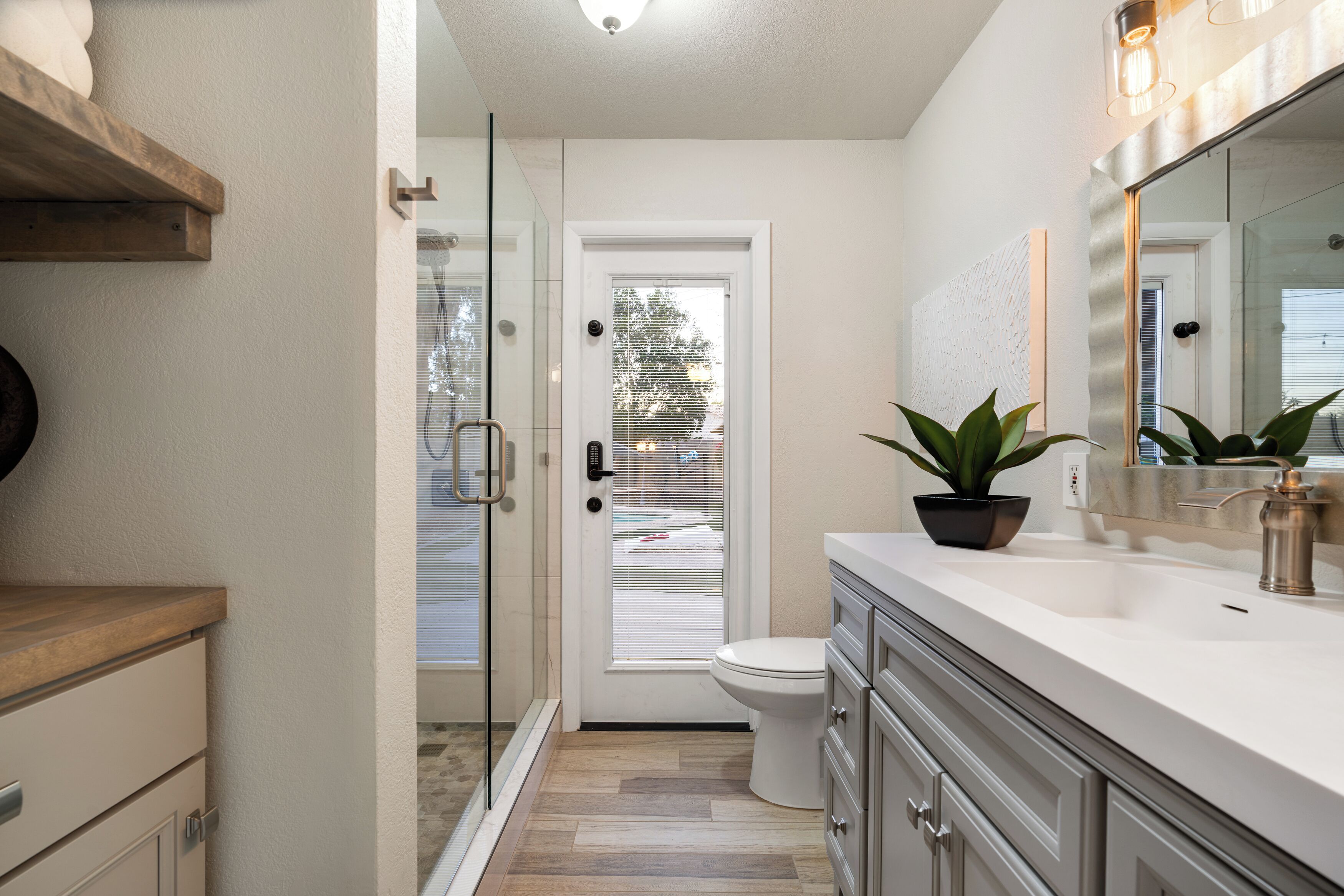 A modern bathroom with a shower, toilet, and sink.