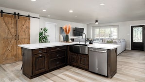 A modern kitchen with dark wood cabinets, a white countertop, and stainless steel appliances.