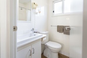 A bathroom with a white sink, toilet, and towel rack.