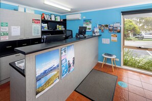 A reception area with a counter, informational posters, and a view of the outside through a window.