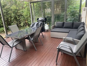 An outdoor patio with a table and chairs, a sofa, and a grill. - 4 BR house near beach sleeps 9 (Warrnambool)