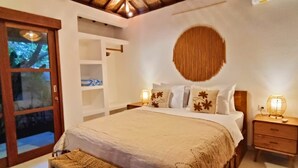 Une chambre à coucher avec un lit, des lampes de chevet, une armoire et une grande fenêtre.