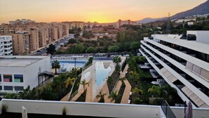 A modern building with a rooftop pool and a view of a cityscape at sunset. - SR Wellingtonia Estepona Downtown (Estepona)