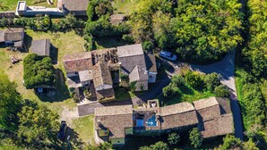 Vista aérea de una zona residencial con varias casas, una piscina y un camino estrecho.
