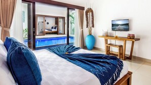 Ein Hotelzimmer mit Bett, Schreibtisch, Fernseher und Blick auf einen Pool.