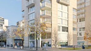 Un immeuble moderne à plusieurs étages, doté de balcons et de grandes fenêtres.