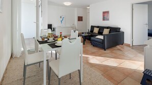 Un salon moderne comprenant un coin repas, un canapé et un téléviseur.