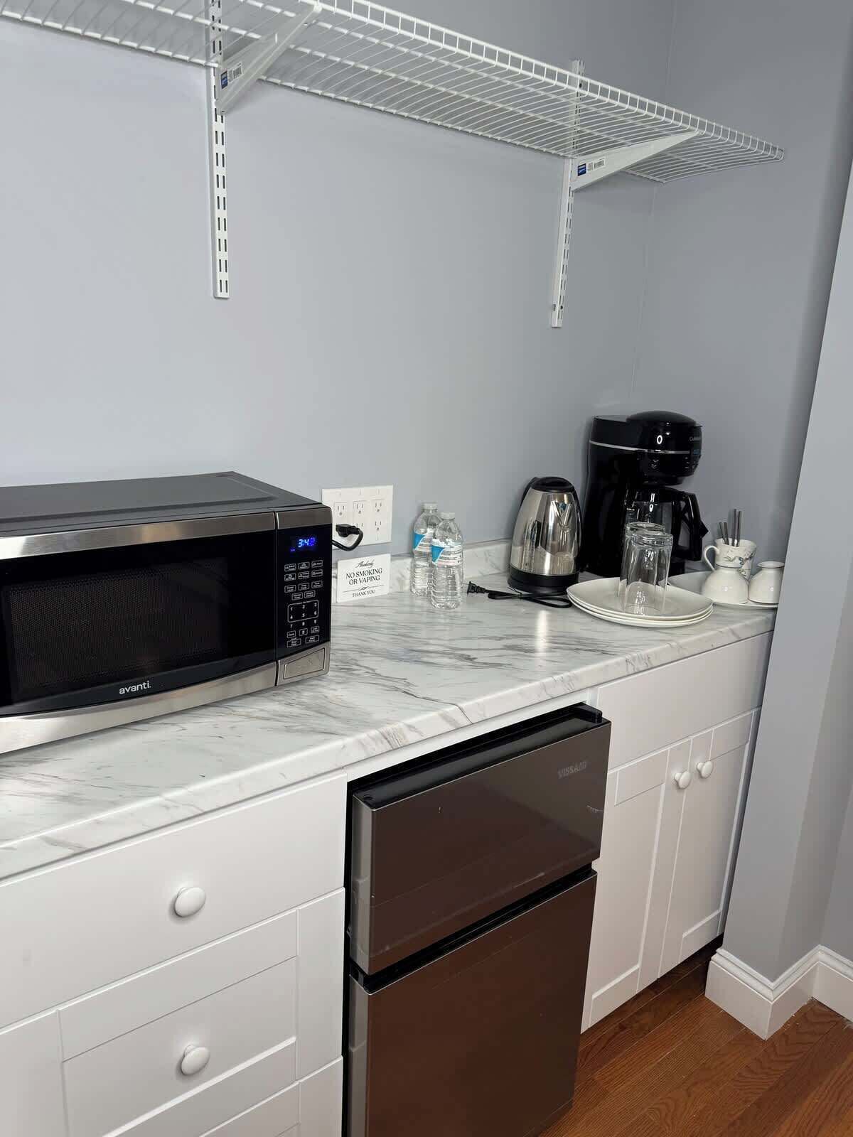 A kitchen with a microwave, coffee maker, and dishwasher.