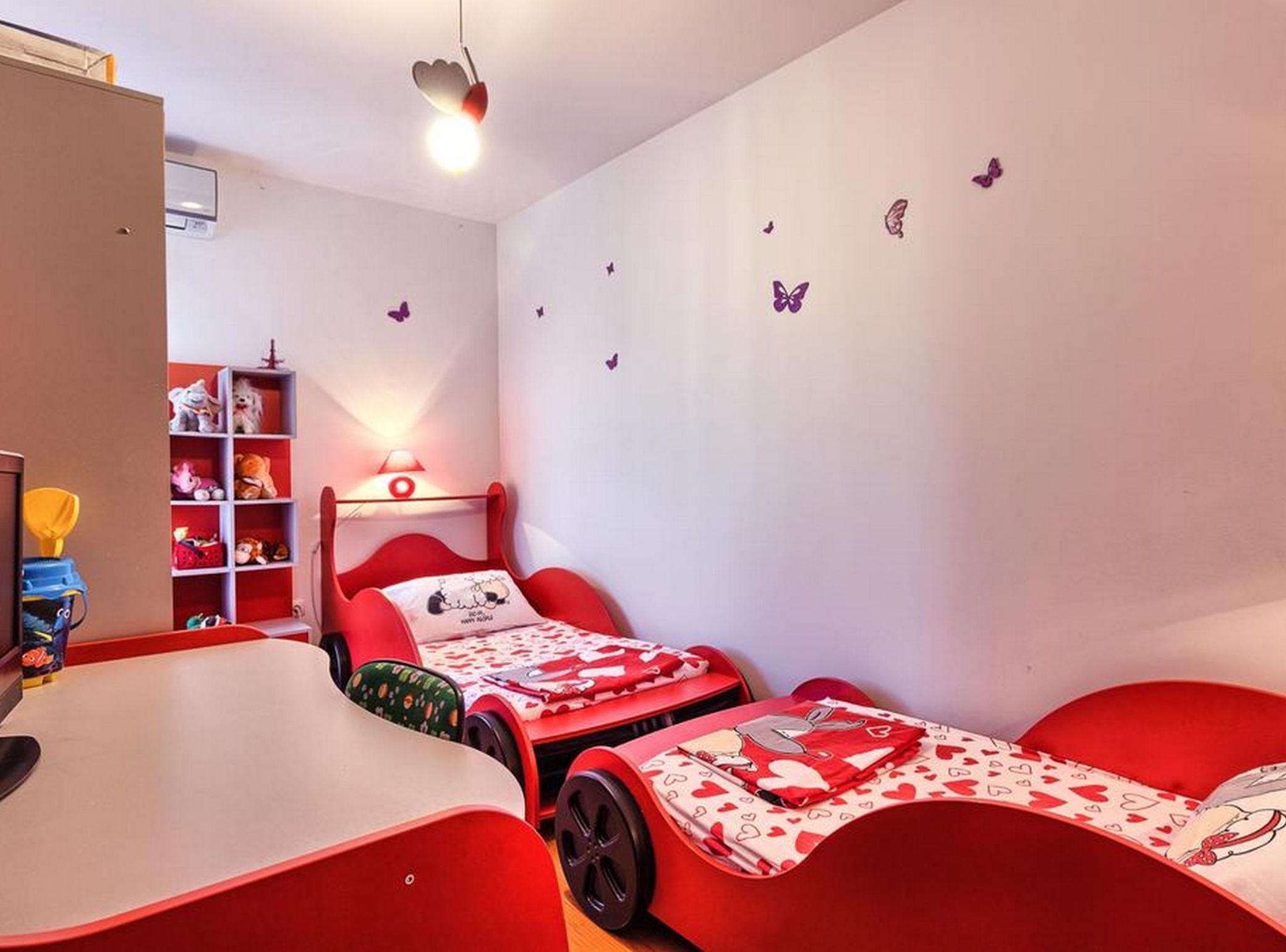 A child's bedroom with a bunk bed, a desk, and a bookshelf.