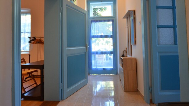 A hallway with a door leading to a room, a small table with chairs, and a window with curtains. - Charming Rovinj Haven (Rovinj)