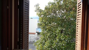 Un umbral abierto que da a un patio con un árbol y un edificio al fondo.