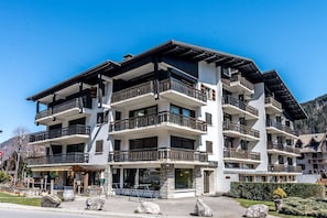 Een hotel met meerdere verdiepingen, balkons, een gevel van natuursteen en een heldere lucht.