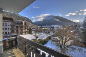 A mountain town with snow-covered streets, buildings, and a prominent mountain in the background.