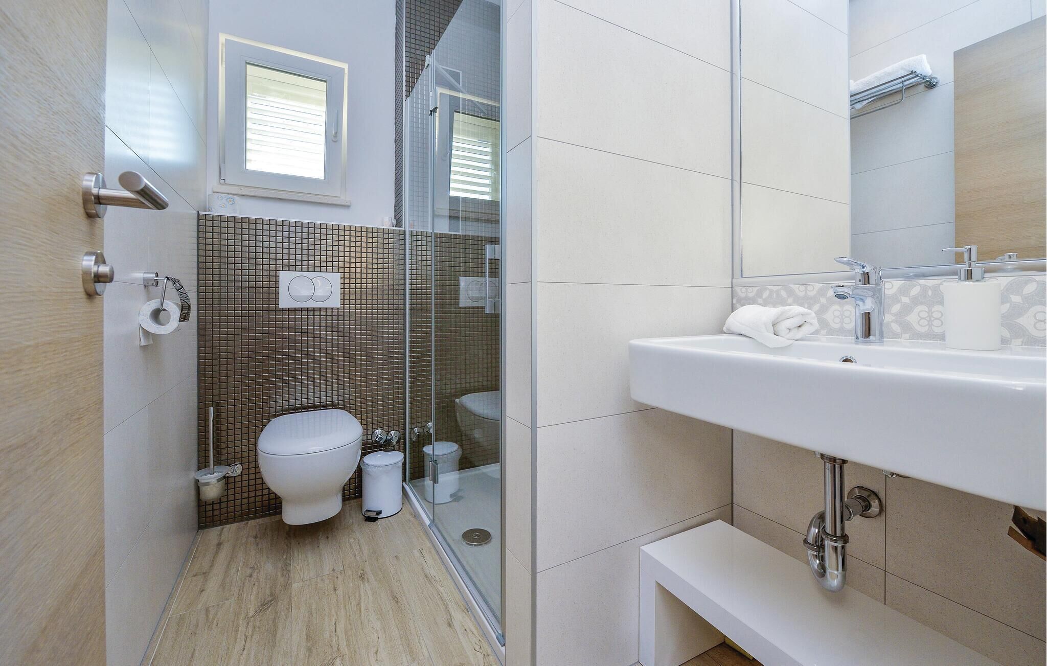 Ein modernes Badezimmer mit Toilette, Bidet und Dusche.