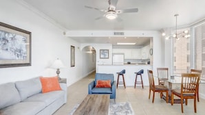A modern living room with a sofa, coffee table, and chairs. There is a kitchen area with a dining table and chairs. - Newly Renovated! 2-Bedroom 2-Bath Stunning LakeView at Blue Heron Beach Resort (Orlando)