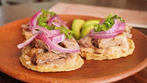 A plate with a dish consisting of meat, onions, and avocado. - Hotel Tepalcates (San Patricio Melaque)