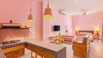 Una cocina moderna con barra, una mesa de comedor y un dormitorio con cama y mesita de noche.