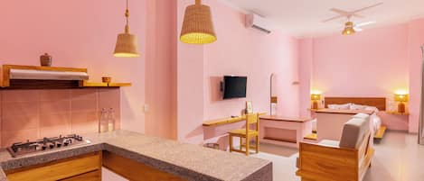 Une cuisine moderne avec un coin bar, une table à manger et une chambre comprenant un lit et une table de chevet.