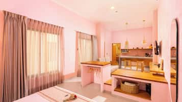 Habitación de hotel con cama, escritorio, kitchenette y baño.
