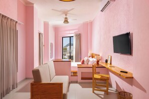 A room with a bed, a desk, a chair, a television, and a window with curtains. - Hotel Tepalcates (San Patricio Melaque)